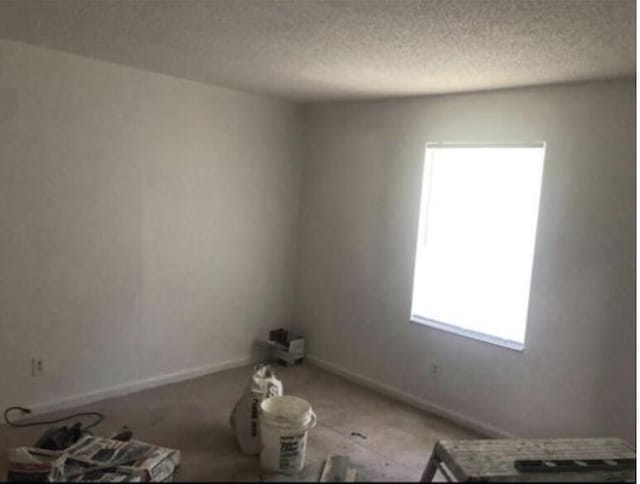 unfurnished room featuring a textured ceiling