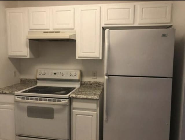 kitchen featuring white cabinets, white appliances, and stone countertops