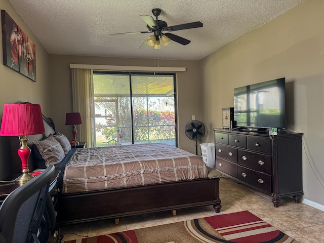 tiled bedroom featuring ceiling fan and a textured ceiling