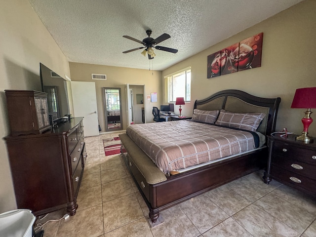 bedroom featuring ceiling fan, a textured ceiling, and light tile floors