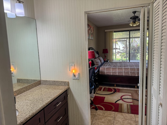 bathroom featuring tile flooring, ceiling fan, a textured ceiling, and vanity