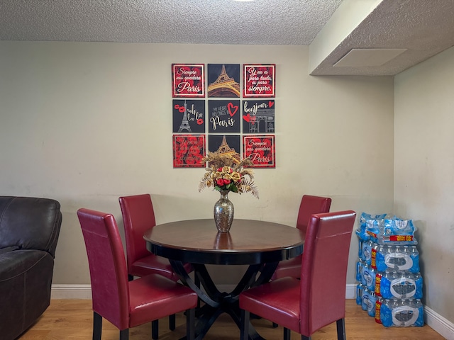 dining room featuring hardwood / wood-style flooring and a textured ceiling