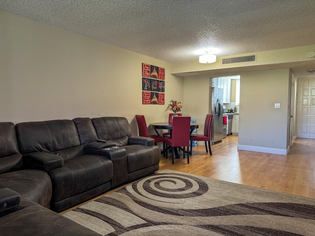 living room with light hardwood / wood-style flooring and a textured ceiling