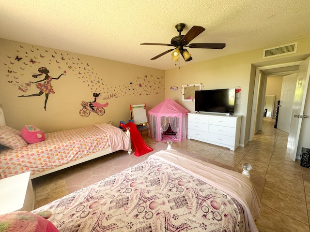 tiled bedroom featuring ceiling fan and a textured ceiling