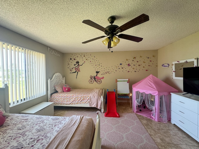 bedroom featuring tile flooring, ceiling fan, and a textured ceiling