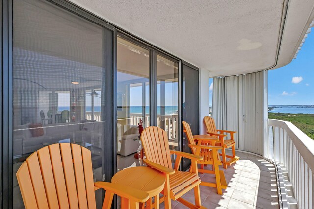 living room featuring ceiling fan and a water view