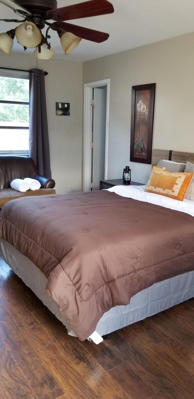 bedroom with ceiling fan and dark wood-type flooring