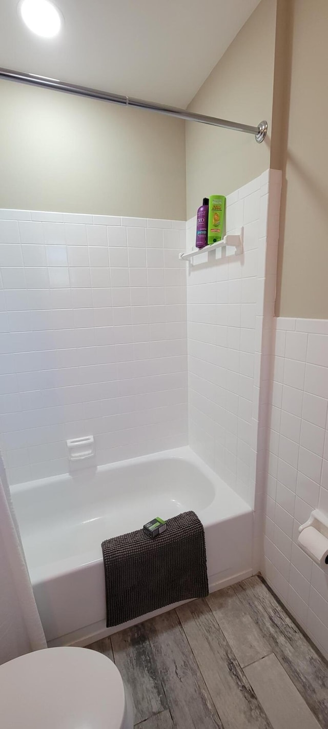 bathroom featuring toilet, bathtub / shower combination, and hardwood / wood-style flooring