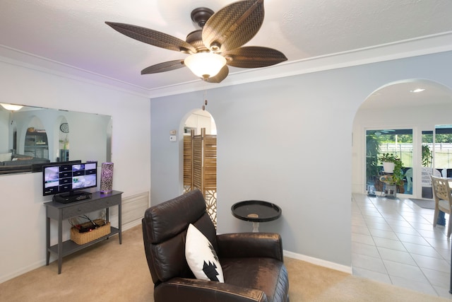 living area with ceiling fan, ornamental molding, and light tile flooring