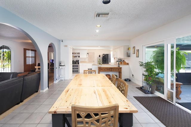 tiled dining space with plenty of natural light and a textured ceiling