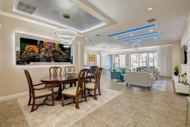 dining area featuring ornamental molding, a chandelier, and light tile flooring