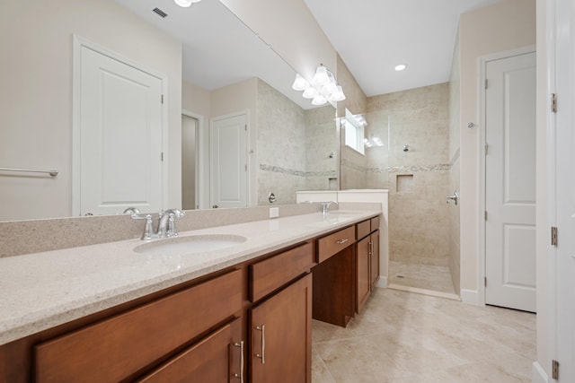 bathroom with dual bowl vanity, tile flooring, and a tile shower