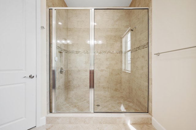 bathroom with tile flooring and a shower with door