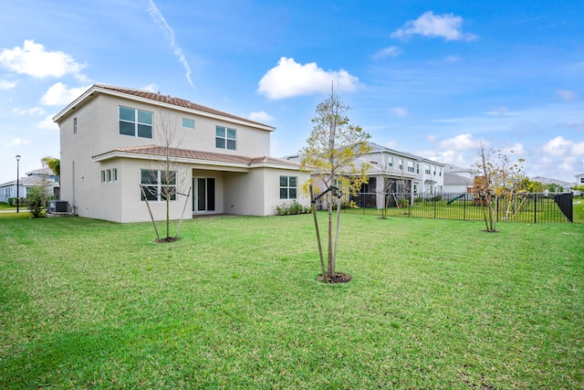 rear view of property with a lawn and central AC unit