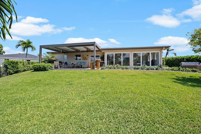 rear view of property featuring a yard, ceiling fan, and a patio area