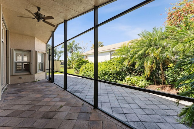 unfurnished sunroom featuring ceiling fan