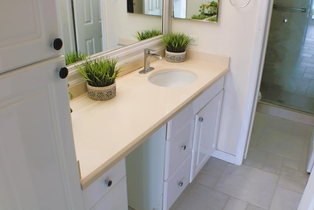 bathroom with vanity, tile flooring, and walk in shower