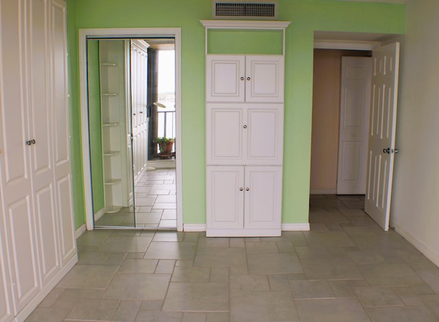 unfurnished bedroom featuring light tile floors