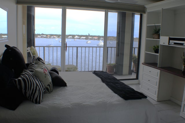 bedroom with light tile flooring and a water view