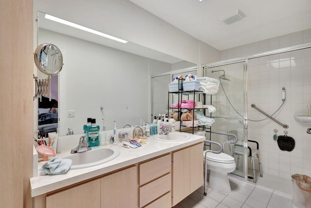 bathroom featuring a shower with shower door, tile patterned flooring, toilet, and double sink vanity