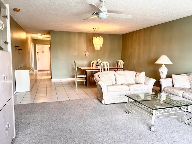 carpeted living room featuring ceiling fan with notable chandelier and a textured ceiling