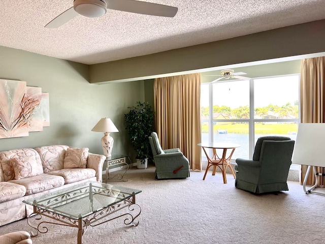 carpeted living room featuring ceiling fan and a textured ceiling