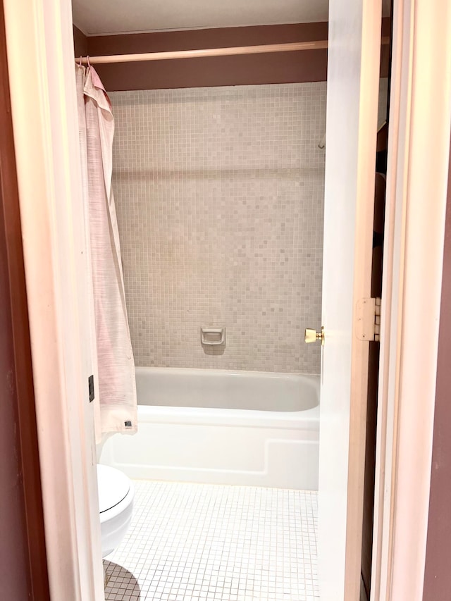 bathroom with tile patterned floors, shower / bath combo, and toilet