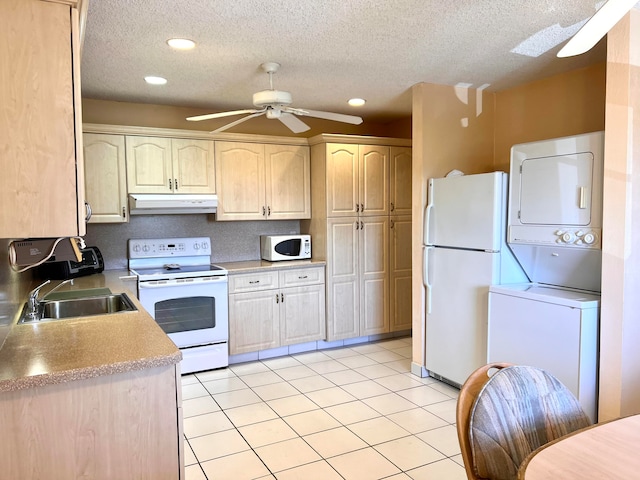 kitchen with white appliances, sink, stacked washer and dryer, ceiling fan, and light brown cabinetry