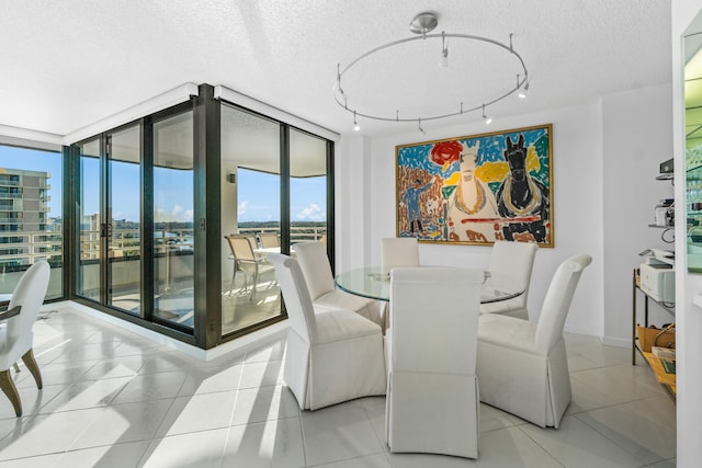 tiled dining room with floor to ceiling windows, a textured ceiling, and track lighting