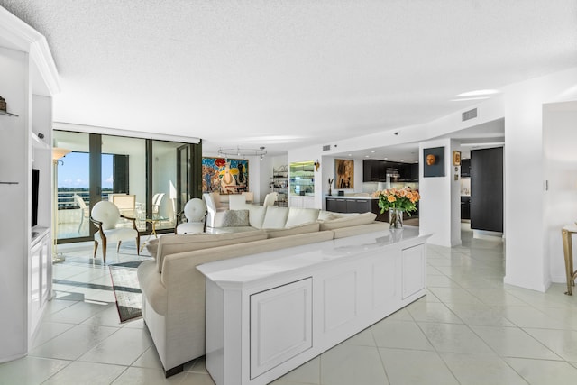 living room featuring floor to ceiling windows, a healthy amount of sunlight, light tile flooring, and a textured ceiling