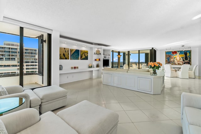 tiled living room featuring a wall of windows and a textured ceiling