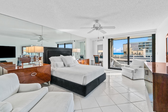 bedroom with multiple windows, ceiling fan, light tile floors, and access to outside