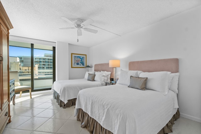 bedroom with ceiling fan, light tile floors, access to outside, and a textured ceiling