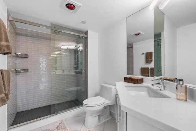 bathroom featuring a shower with door, vanity with extensive cabinet space, tile floors, and toilet