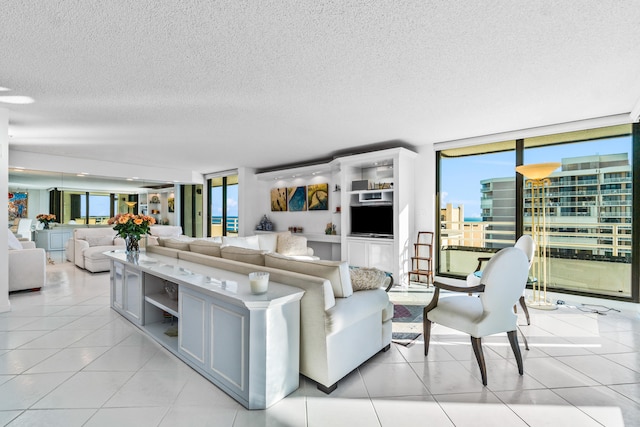 living room featuring a wall of windows, a textured ceiling, and light tile flooring