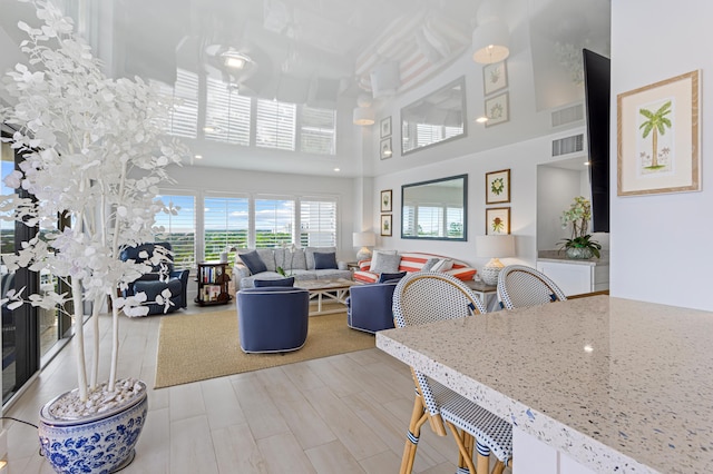 living room featuring light hardwood / wood-style floors and a high ceiling