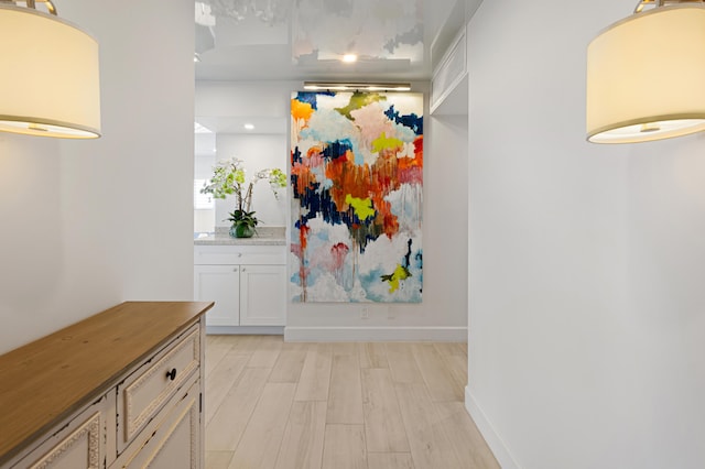 hallway with light hardwood / wood-style floors