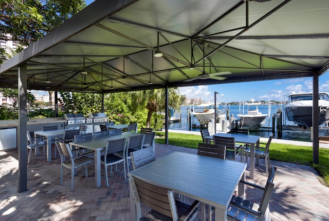 view of patio featuring a dock, a water view, and grilling area