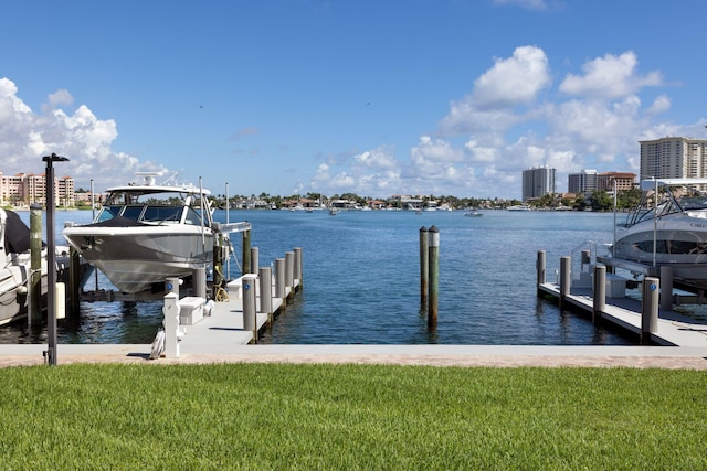 view of dock with a lawn and a water view