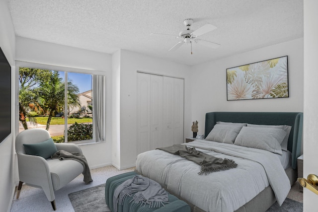 bedroom featuring ceiling fan, a textured ceiling, a closet, and carpet