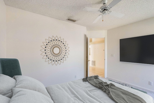 bedroom with ceiling fan and a textured ceiling