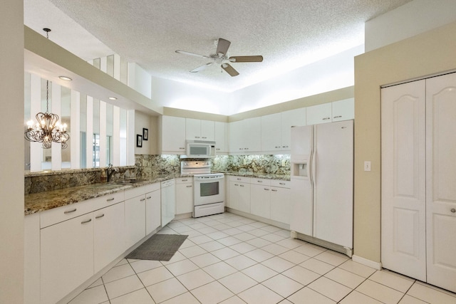 kitchen featuring white appliances, white cabinetry, a textured ceiling, and decorative backsplash