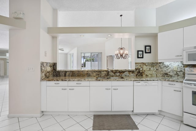 kitchen with a textured ceiling, sink, vaulted ceiling, white cabinets, and white appliances