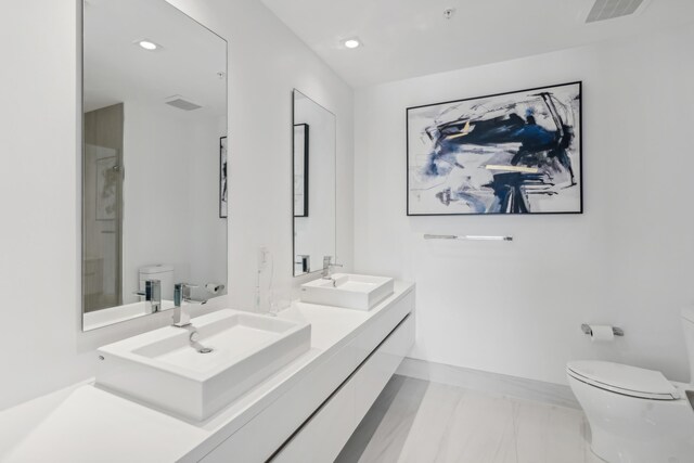 bathroom with tile patterned floors, vanity, a shower, and toilet