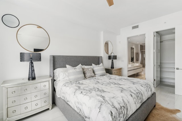 bedroom with a walk in closet, ceiling fan, a closet, and ensuite bath