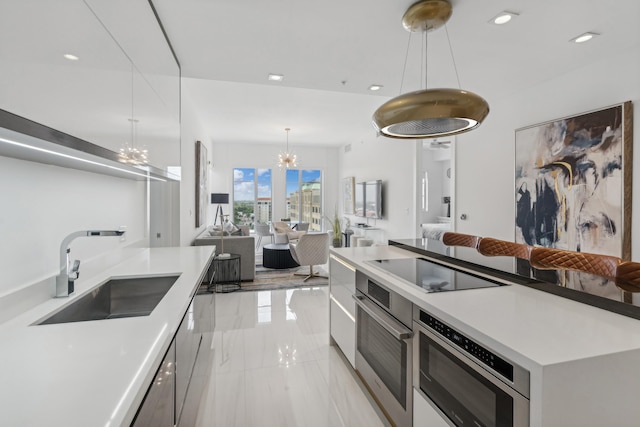 kitchen with a chandelier, sink, light tile patterned floors, stainless steel oven, and hanging light fixtures