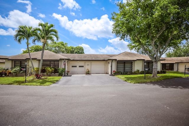 ranch-style house with a garage and a front yard