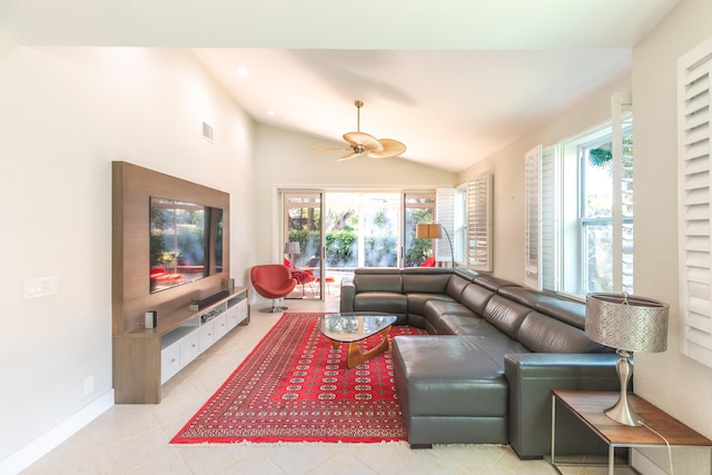 living room with light tile floors, plenty of natural light, lofted ceiling, and ceiling fan