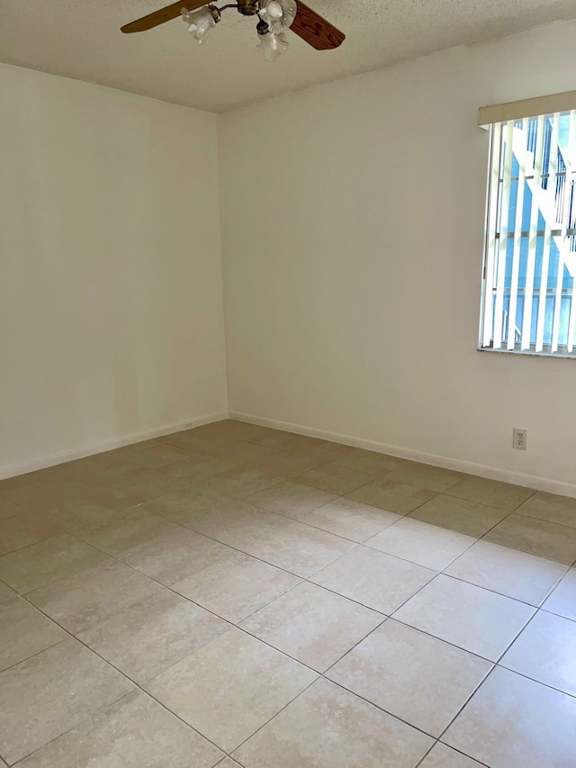 tiled spare room with ceiling fan and a textured ceiling