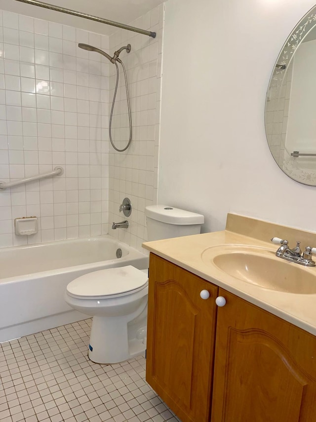 full bathroom featuring tiled shower / bath, vanity, toilet, and tile patterned floors